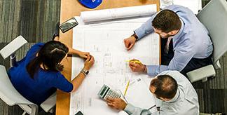 Three people planning at a table